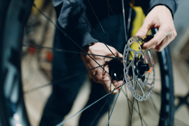 istock Mechanic repairman assembling wheel disc brakes custom bicycle in workshop. 1460814472