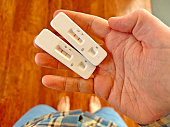 Hand holding Covid-19 rapid antigen test cassette with positive result of rapid diagnostic test
