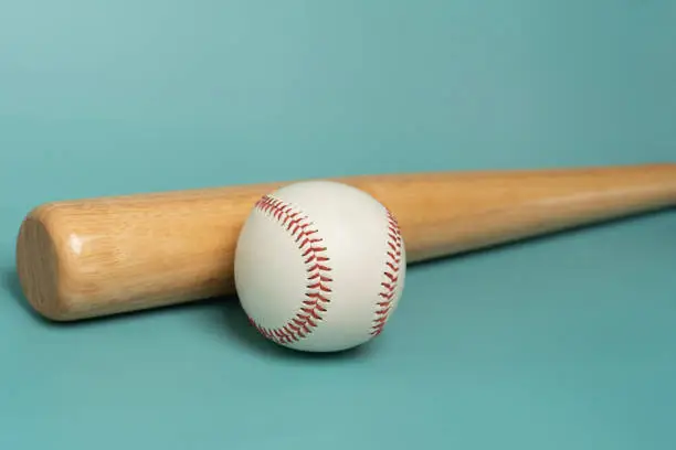 Photo of close up baseball and baseball bat on green table  background,  sport concept