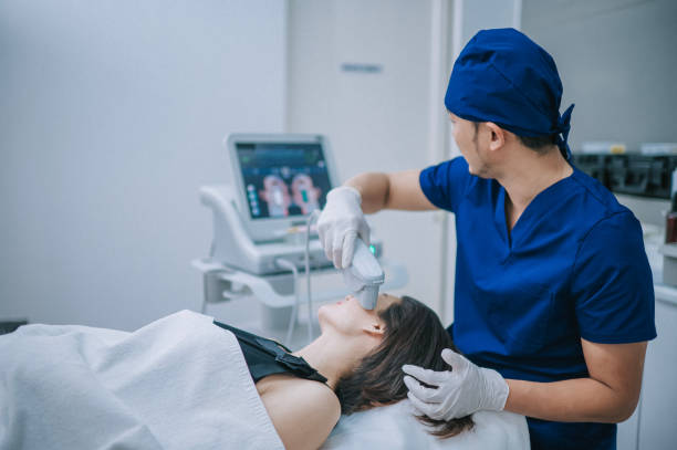 asian chinese male aesthetician using ultrasound smas face lifting on patient face - exfoliating scrub imagens e fotografias de stock