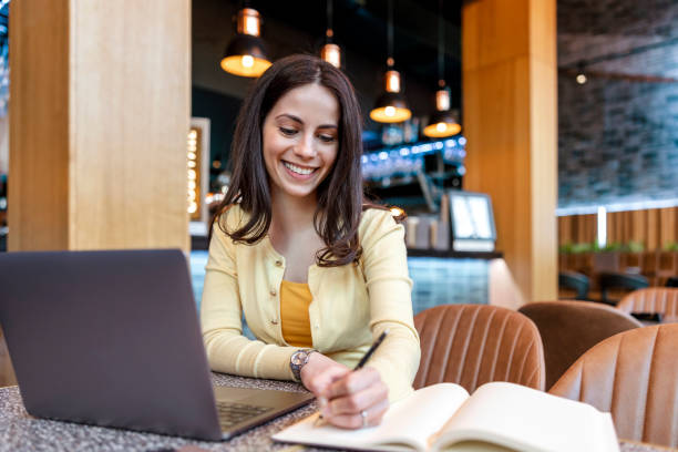 istock Young businesswoman using laptop while working in a modern coffee shop 1460819928