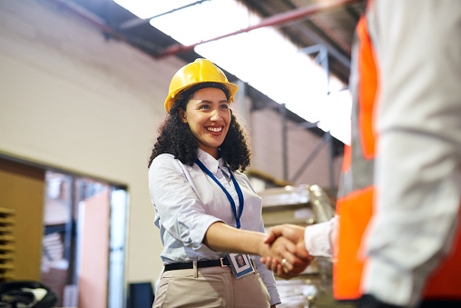 Business, woman and engineer handshake, partnership and greeting in warehouse, confident and agreement. Corporate deal, female employee and entrepreneur with gesture, collaboration and new project