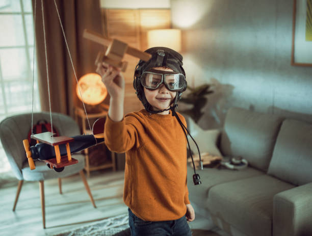 pilot aviator kind mit einem spielzeugflugzeug spielt zu hause - discovery aspirations pilot child stock-fotos und bilder