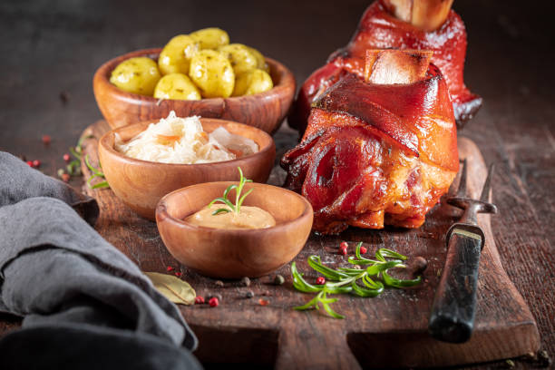Cripsy roasted pork knuckle served with sauerkraut and potatoes. stock photo