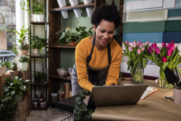 テクノロジーで中小企業を経営する日常業務 - florist small business flower shop owner ストックフォトと画像