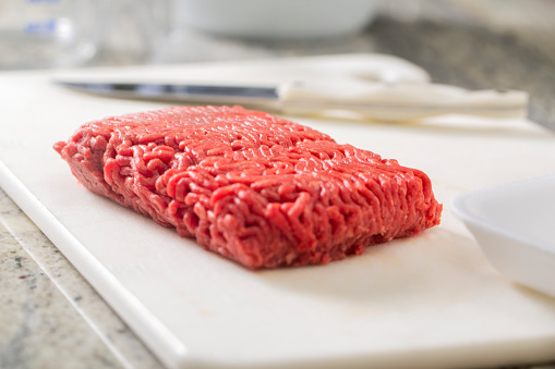 Food Safety - Fresh lean ground beef on cutting board in modern USA kitchen.