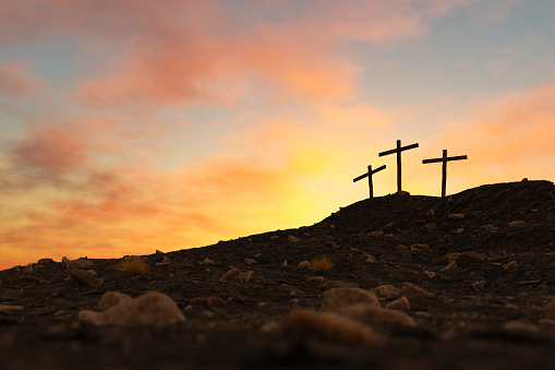 From below of silhouettes of catholic crosses on top of rocky mountain against picturesque cloudy sunset sky. 3d rendering