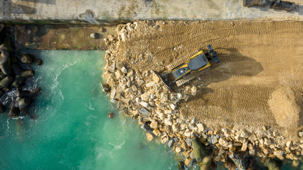 istock Aerial view of waterfront construction site with excavator. Bulldozer working on a breakwater construction 1460836779