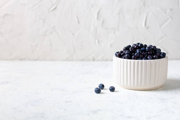 istock Fresh ripe blueberries in white ceramic bowl on table. 1460836887