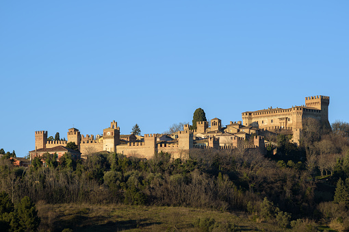 Gradara, Italy - Janary 10, 2023: The castle of Gradara seen from afar with copy space in the sky. Gradara is a middle age italian village near Urbino famous for the stoy of Paul and Francesca in Dante Alighieris Divine Comedy