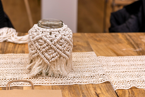 Macramé. The art of knot tying. Finished glass jar covered with macramé. Lifestyle home.