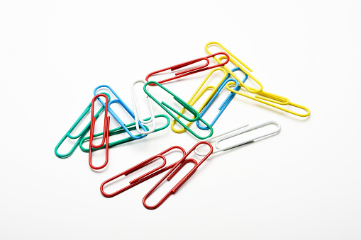 Colorful paperclips on the white background