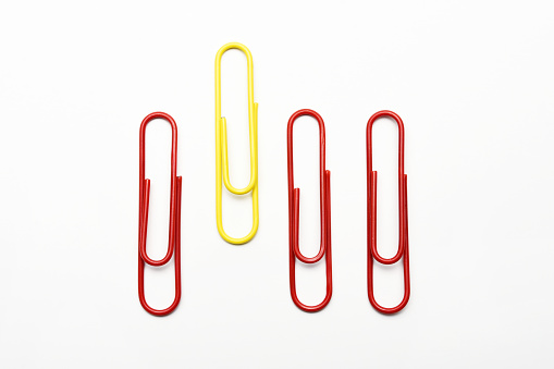 Leadership concept. Colorful paperclips on the white background