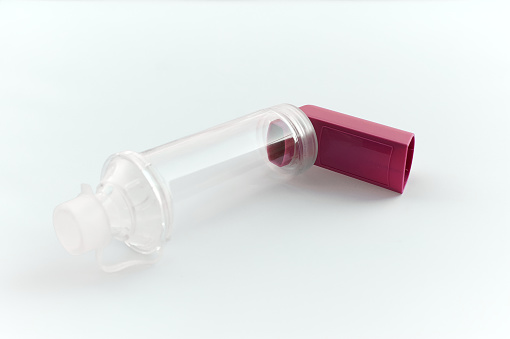 Lung medication with corticosteroids for asthma or COPD. An inhaler with spacer with white background.