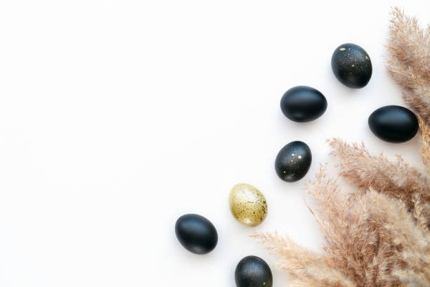 istock Eggs painted gold and black on white background. Minimal Easter concept with copy space for text. 1460844654