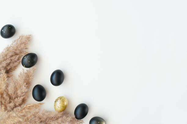 istock Eggs painted gold and black on white background. Minimal Easter concept with copy space for text. 1460844725