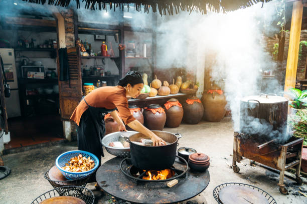 istock woman cooking steamed fish on open fire in restaurant 1460845360