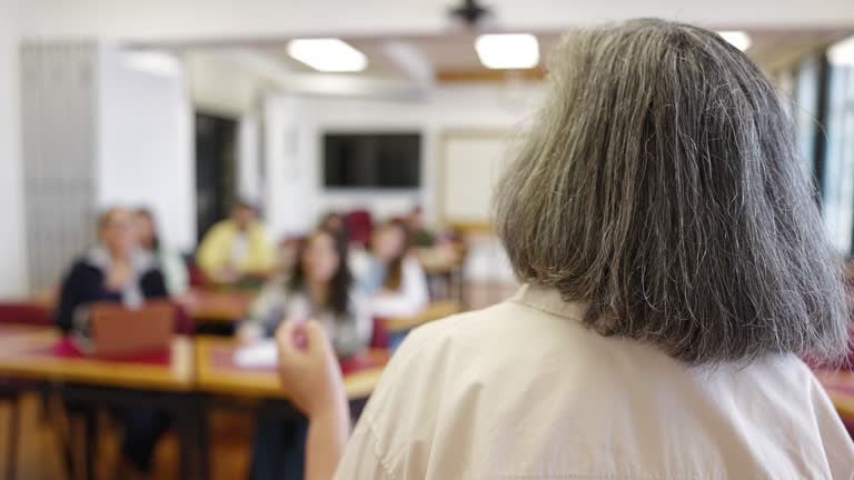 Educator and students in college classroom