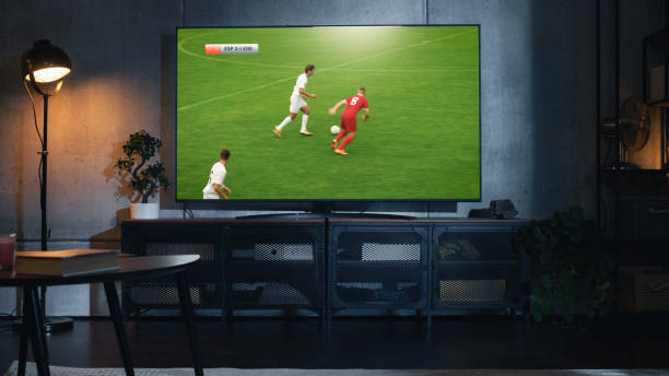 大きなフラットスクリーンテレビセットでサッカーの試合をしたテレビのショット。スポーツチャンネルでのサッカー世界選手権決勝の生放送。ストリリッシュロフトアパートメントリビン� - loft apartment indoors contemporary sparse ストックフォトと画像