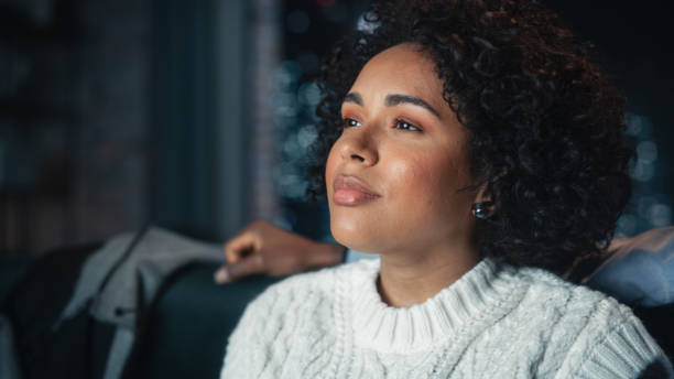 istock Focus on Black Female Sitting With Her Husband on a Sofa and Laughing While Watching Comedy TV Show. People Resting Together on Couch During the Weekend at Night, Enjoying Funny Film. 1460849771