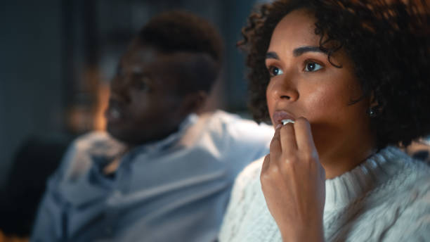 istock Portrait of Young Romantic Couple Talking and Eating Popcorn While Watching on Demand Streaming Service Hit TV Show, Movie During the Evening at Home. Boyfriend and Girlfriend Spend Time Together. 1460849963