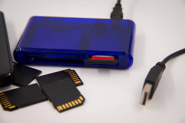 istock Black memory cards and external hard drive with blue card reader and card in it on white background. 1460850253