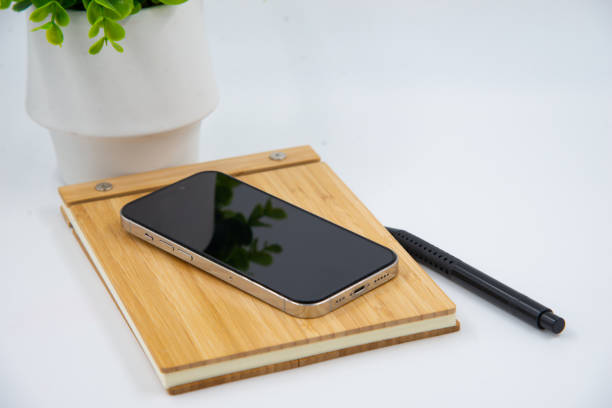 istock Mobile smart phone with blank screen of gadget on notebook. Digital cell phone with copy space area on white background with pencil and leaf 1460850329