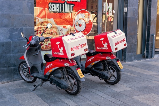 Barcelona, Spain-January 17, 2023. Delivery motorbikes of Telepizza, a Spanish multinational pizzeria chain with a presence in several countries around the world. San Sebastián de los Reyes, Madrid