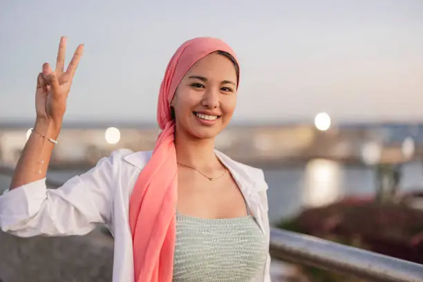 Photo of asian woman fight cancer pink scarf