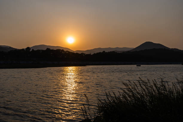 istock Sunset Behind the Mountains Next to a River 1460854964