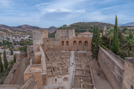 Spectacular view of Alcazaba medieval fortress from inside. Sight of the fortified walls and towers in the Arab, Moorish style. Amazing skies above. Alhambra de Granad, Andalusia, Spain.