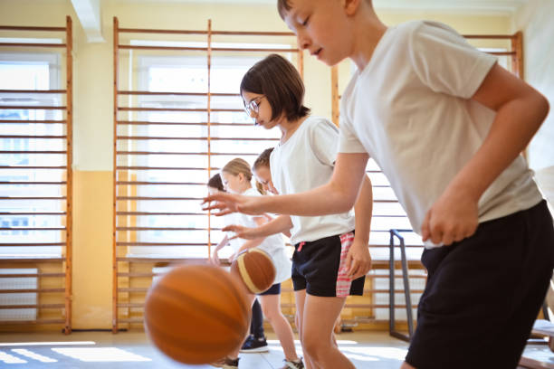 istock School boys and girls practicing dribbling during sport lesson 1460858141