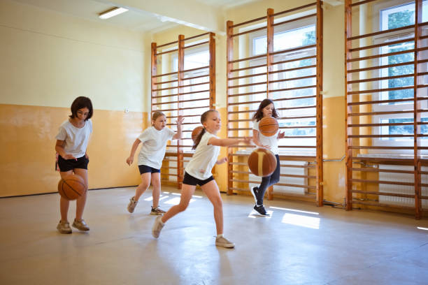 istock School girls practicing dribbling during sport lesson 1460858293