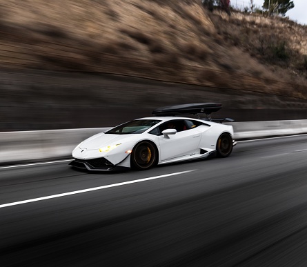 LA, CA, USA\n1/27/2023\nWhite Lamborghini Huracan parked on a mountain road with hills in the background