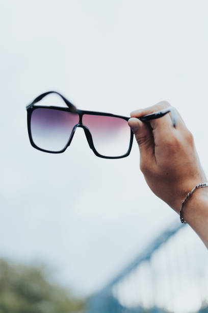 istock Young Man Holding Sunglasses Against Sky 1460860807