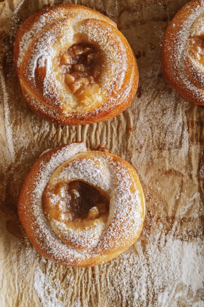 istock Freshly baked pastries with jam on baking paper decorated with sugar powder 1460860877