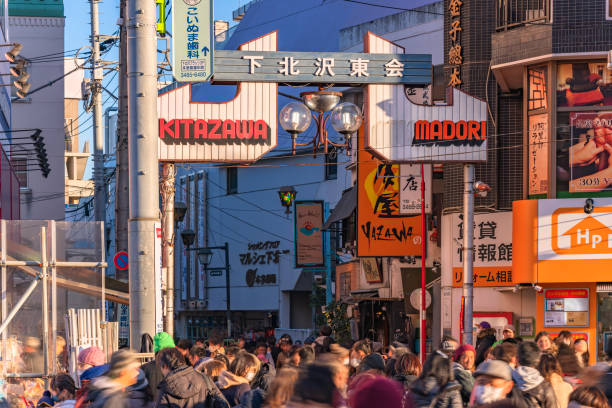 Main gate of the Azuma Dori shopping street meaning of Shimokitazawa with crowds of people. tokyo, setagaya - january 28 2023: Main gate of the Azuma Dori shopping street meaning East Street in the district of Shimokitazawa with crowds of people strolling during the tengu parade festival. setagaya ward stock pictures, royalty-free photos & images