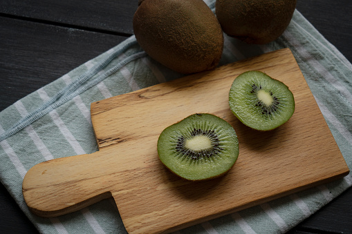 Ripe kiwi and avocado cut into slices, on an old wooden table, top view