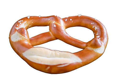 Brezel lies in a plate on a wooden table in a cafe, isolated on a white background