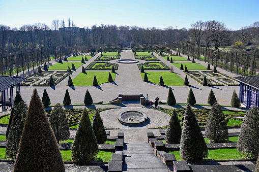 Stylish granite staircase with a balustrade with beautiful carved balusters in classic style, overlooks the beautiful lawn of a magnificent garden.