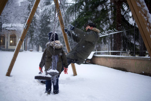 istock boy swinging in the snow 1460865580