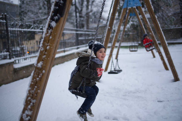 istock boy swinging in the snow 1460865590