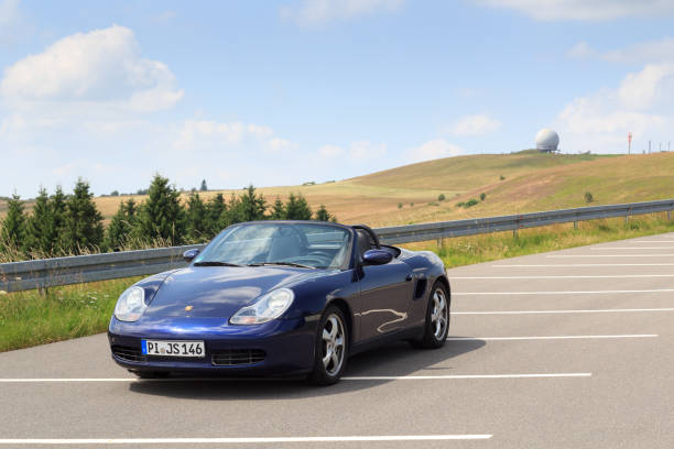 gersfeld, alemania - 23 de julio de 2021: roadster azul porsche boxster 986 con panorama wasserkuppe y cúpula de radar en las montañas rhön. el coche es un coche deportivo biplaza de motor central fabricado por porsche. - germany landscape nissan roadster fotografías e imágenes de stock