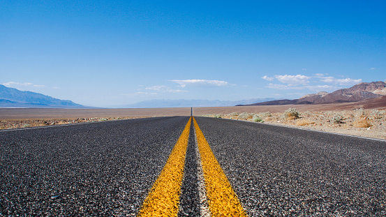 Endless road through the Death Valley National Park in america on a hot summer day