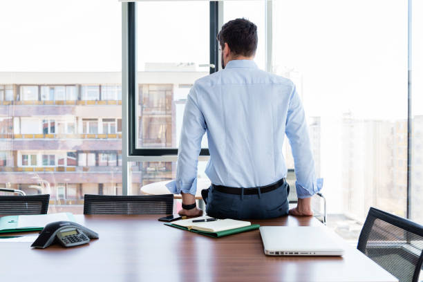 istock Thinking businessman sitting with his back at the office 1460871717