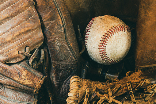 Close-up of a baseball in a vintage baseball glove.