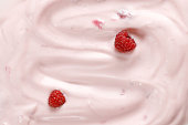 Pink Yogurt with raspberries. Curl of Yogurt. Pink nature yogurt, sour cream, ice cream. Delicious liquid Texture, background. Top view.