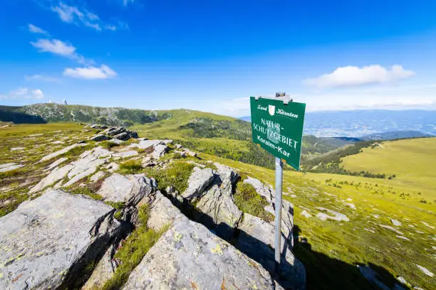 Information sign of the conservation area Koralm Kar on a mountain ridge in Austria