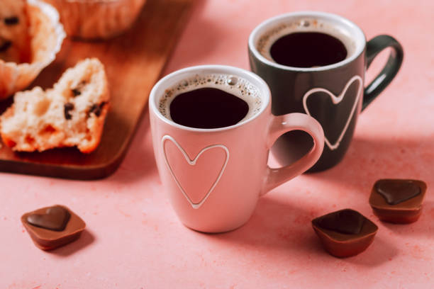 deux tasses à café avec cœur en couleurs rose et noire, muffins et chocolats en gros plan - old fashioned horizontal black coffee cup photos et images de collection