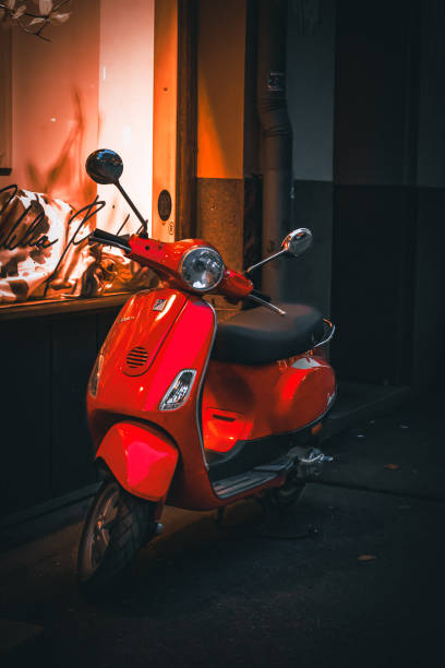 Helsinki, November 28th 2022: a bright red colored scooter parked next to a house in downtown Helsinki.